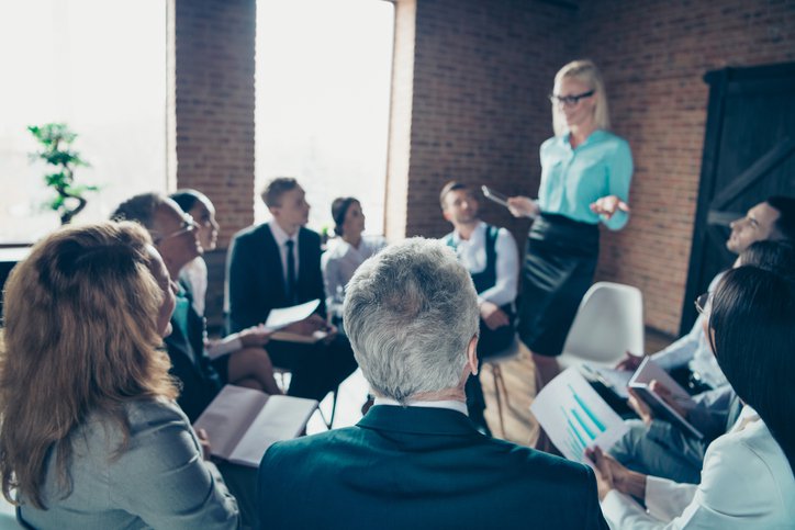 woman teaching group of people - real estate investment training program dallas tx