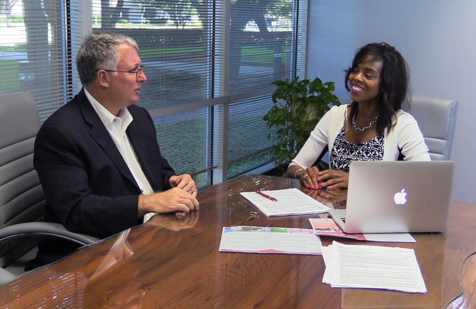 two people at desk smiling - best real estate investment training academy dallas texas