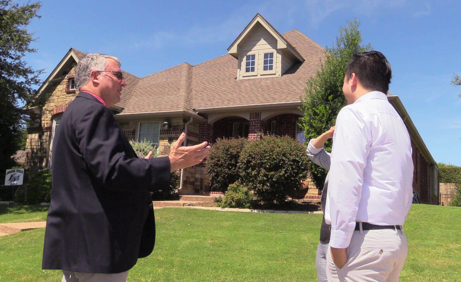 two people in front of home - best real estate investment training academy dallas texas